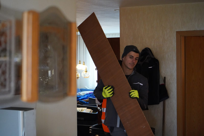 Tontshew Mitarbeiter trägt während Entrümpelung Jettingen Holzplatte aus Wohnung