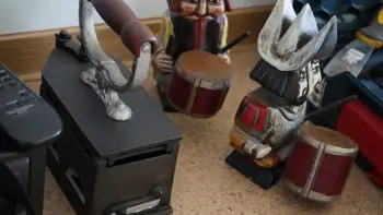 Farbeimer und Gegenstände vor der Räumung Farbeimer, Beutel und ein dunkles Möbelstück in einem Innenraum.